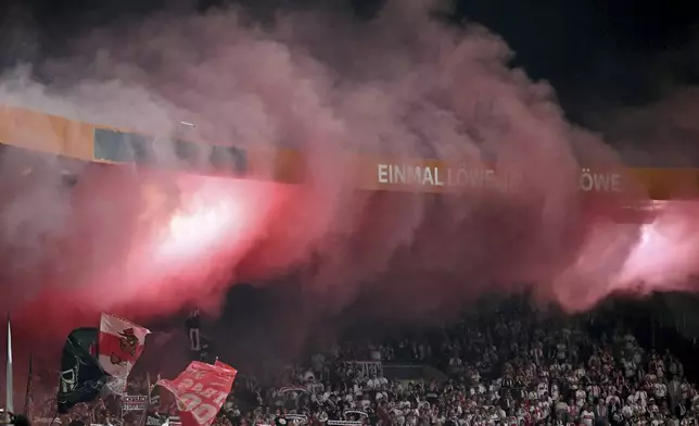 Fans set off pyrotechnics during a DFB Pokal, German Cup, soccer match between VfB Stuttgart and Eintracht Braunschweig, Tuesday, Aug. 26, 2205, in Brunswick, Germany. (Swen Pförtner/dpa via AP)