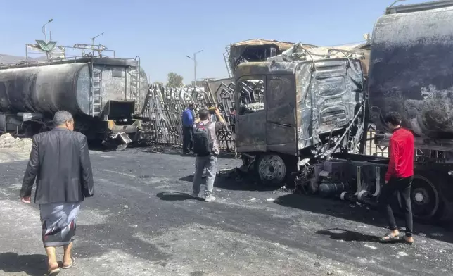 People watch damaged vehicles and buildings a day after Israeli airstrikes on the main gas station in Sanaa, Yemen, Monday, Aug. 25, 2025. (AP Photo)