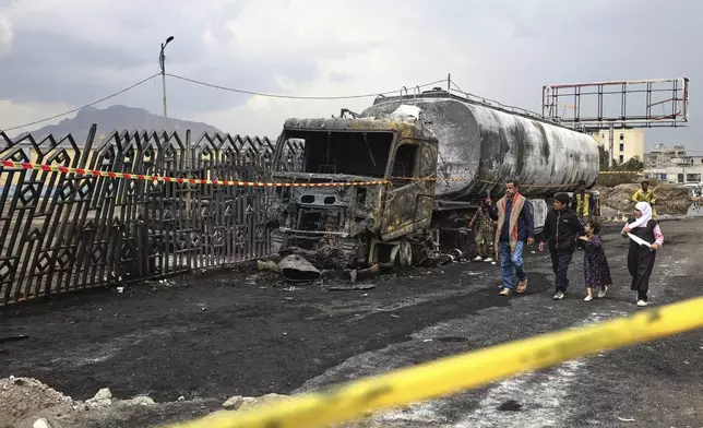 People walk past the wreckage of a fuel truck destroyed in Israeli airstrikes on Sunday, in Sanaa, Yemen, Monday, Aug. 25, 2025. (AP Photo)