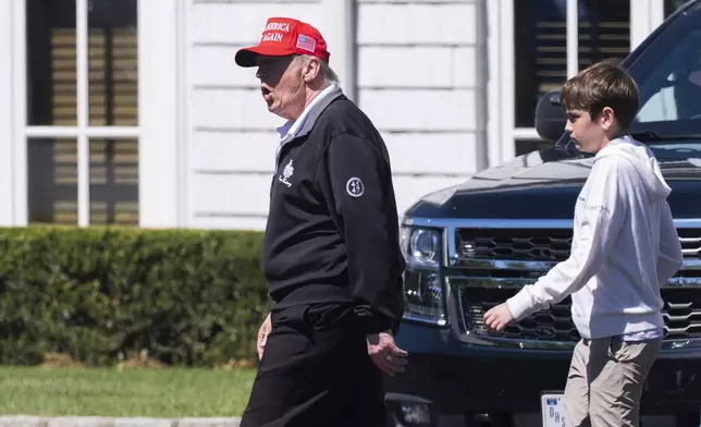 President Donald Trump, left, walks with his grandson Spencer Trump at the Trump National Golf Club in Sterling, Va., Saturday, Aug. 30, 2025. (AP Photo/Manuel Balce Ceneta)