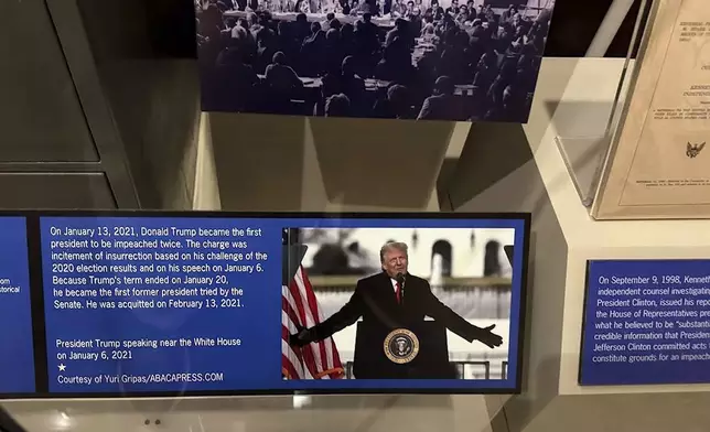 A new sign at the presidential impeachment exhibit in the Smithsonian’s National Museum of American History in Washington, describes the counts against President Donald Trump in his second impeachment trial. The Senate acquitted him in both trials. The sign, seen here Aug. 26, 2025, replaces earlier, temporary text but still addresses what he was charged for. (AP Photo/Calvin Woodward)
