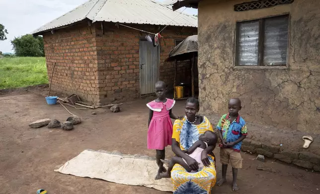 Joy Falatiya, a 35-year-old mother of five children and a client of a specialized mental health clinic led by Amref Health Africa, poses for a photo with her three children in Mundri, South Sudan, June 24, 2025. (AP Photo/Florence Miettaux)