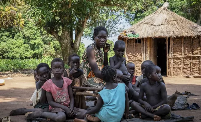 Vobia Kawaja, a 34-year-old mother of five, sits outside her home with her children and neighbors' children in Kotobi, Mundri West County, South Sudan, June 26, 2025. (AP Photo/Florence Miettaux)