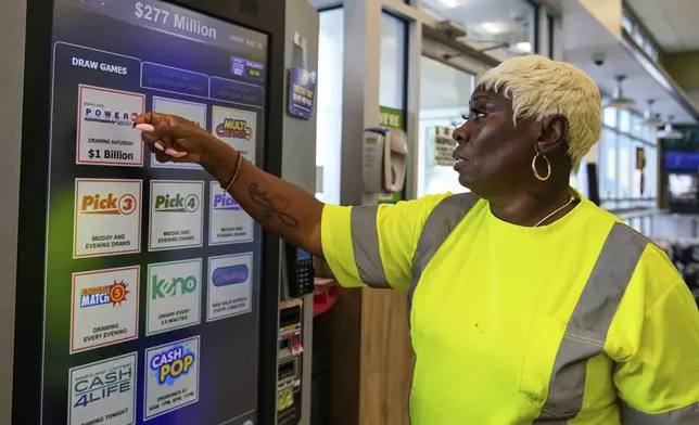 Roslyn Jefferson makes her lottery ticket selections on a self-serve terminal inside a gas station ahead of Saturday's Powerball drawing offering of $1 billion, Friday, Aug. 29, 2025, in Baltimore. (AP Photo/Stephanie Scarbrough)