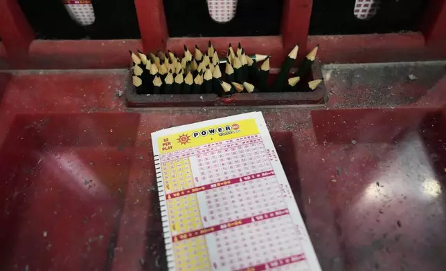 A Powerball play slip sits on the lottery ticket counter at a gas station, Friday, Aug. 29, 2025, in Baltimore. (AP Photo/Stephanie Scarbrough)