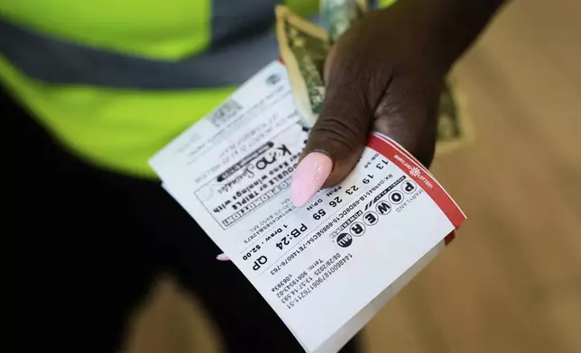 Roslyn Jefferson holds her Powerball lottery tickets ahead of Saturday's Powerball drawing offering of $1 billion, Friday, Aug. 29, 2025, in Baltimore. (AP Photo/Stephanie Scarbrough)