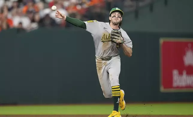 Athletics shortstop Jacob Wilson throws to first for an out after fielding a ground ball by Houston Astros' Cooper Hummel during the fifth inning of a baseball game Friday, July 25, 2025, in Houston. (AP Photo/David J. Phillip)