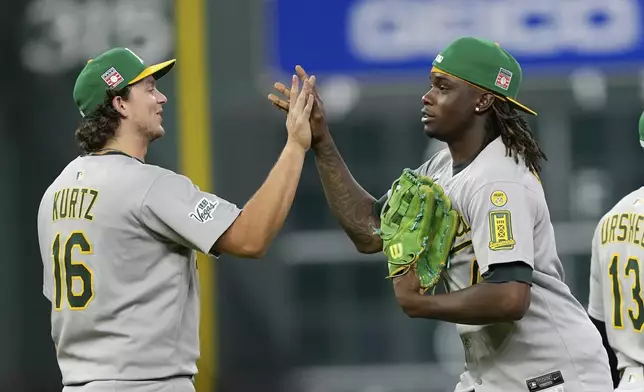 Athletics' Nick Kurtz (16) and Lawrence Butler celebrate after a baseball game against the Houston Astros Saturday, July 26, 2025, in Houston. (AP Photo/David J. Phillip)
