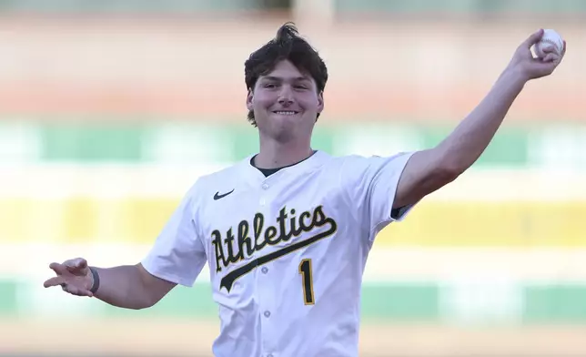 Athletics' 2025 first-round pick Jamie Arnold throws out a ceremonial first pitch before a baseball game against the Seattle Mariners, Monday, July 28, 2025, in West Sacramento, Calif. (AP Photo/Scott Marshall)