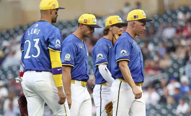 Minnesota Twins starting pitcher Pierson Ohl, far right, reacts during a mound visit in the first inning of a baseball game against the Detroit Tigers, Friday, Aug. 15, 2025, in Minneapolis. (AP Photo/Matt Krohn)