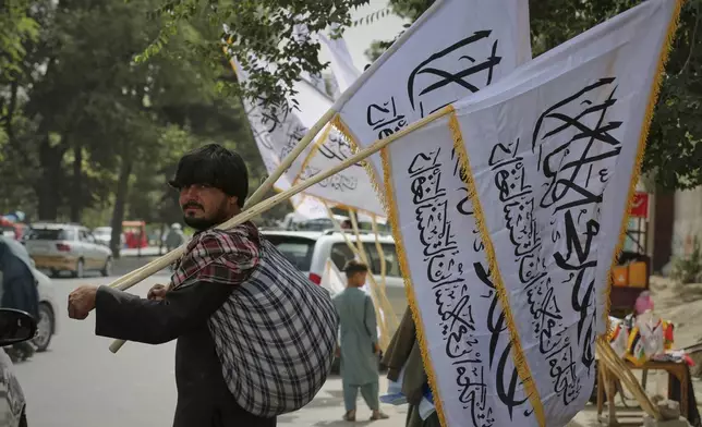 A man sells Taliban flags ahead of celebrations marking the fourth anniversary of the U.S. withdrawal from Afghanistan and the start of Taliban rule in Kabul, Afghanistan, Thursday, Aug. 14, 2025. (AP Photo/Siddiqullah Alizai)