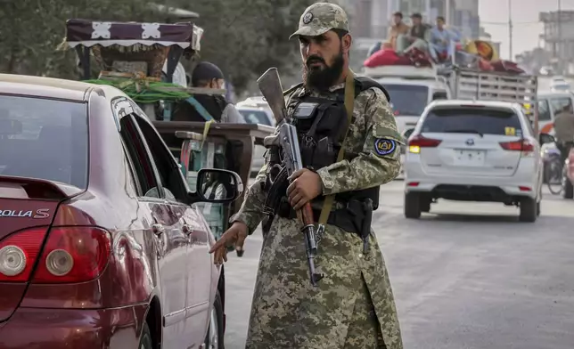 A Taliban policeman directs traffic on the eve of celebrations marking the fourth anniversary of the U.S. withdrawal from Afghanistan and the start of Taliban rule, in Kabul, Afghanistan, Thursday, Aug. 14, 2025. (AP Photo/Siddiqullah Alizai)