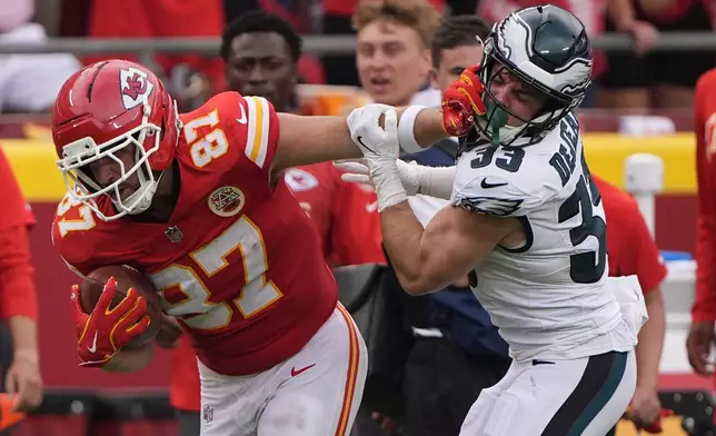 Kansas City Chiefs tight end Travis Kelce (87) runs for a first down as Philadelphia Eagles defensive back Cooper DeJean (33) defends during the second half of an NFL football game Sunday, Sept. 14, 2025, in Kansas City, Mo. (AP Photo/Charlie Riedel)