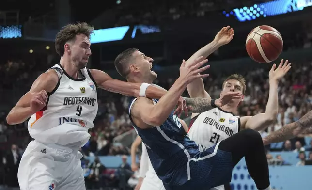 Germany's Franz Wagner, left, Slovenia's Alen Omic, centre, Germany's Justus Hollatz in action during the Eurobasket, European Basketball Championship quarter final match between Germany and Slovenia at the Riga Arena in Riga, Latvia, Wednesday, Sept. 10, 2025. (AP Photo/Sergei Grits)