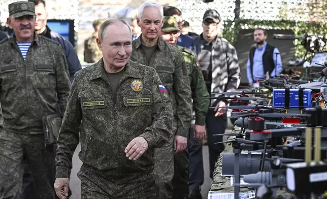 CORRECTS SOURCE FOR POOL - Russian President Vladimir Putin accompanied by Deputy Defence Minister Yunus-Bek Yevkurov, left, and Defence Minister Andrei Belousov, right, inspects Russian weapons and equipment during his visit to the Russian-Belarusian joint military drills "Zapad 2025" (West 2025) at the Mulino training ground in Nizhny Novgorod region, Russia, Tuesday, Sept. 16, 2025. (Sergey Bobylev/Sputnik, Kremlin Pool Photo via AP)