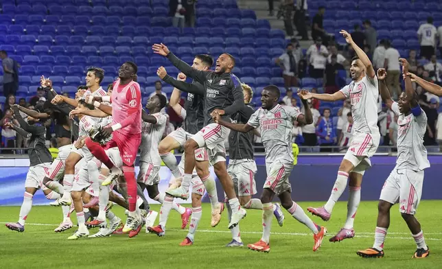 Lyon players celebrate their victory at the French League One soccer match between Olympique Lyon and Angers at Groupama stadium in Decines, outside Lyon, France, Friday, Sept. 19, 2025. (AP Photo/Laurent Cipriani)