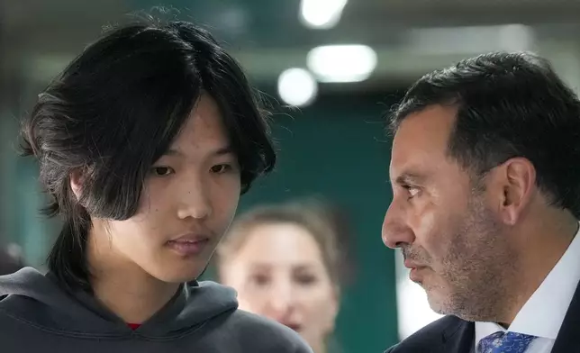 U.S. influencer Ethan Guo, left, talks with his lawyer Jaime Barrientos prior to an event for his donation to children's cancer rehabilitation programs in Santiago, Chile, Tuesday, Sept. 9, 2025. (AP Photo/Esteban Felix)