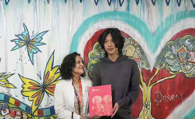 U.S. influencer Ethan Guo, right, stands with Marcela Zubieta, director of "Fundacion Nuestros Hijos" at an event about his donation to children's cancer rehabilitation programs in Santiago, Chile, Tuesday, Sept. 9, 2025. (AP Photo/Esteban Felix)