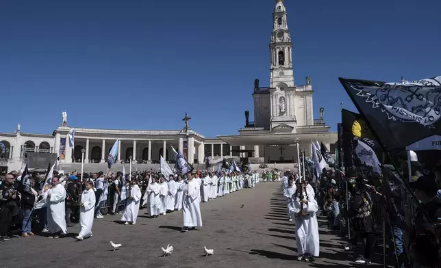 A procession move through the crowd at the end of mass during the 10th Pilgrimage of the Blessing of Helmets that draws tens of thousands, at the Roman Catholic holy shrine of Fatima, in Fatima, Portugal, Sunday, Sept. 21, 2025. (AP Photo/Ana Brigida)