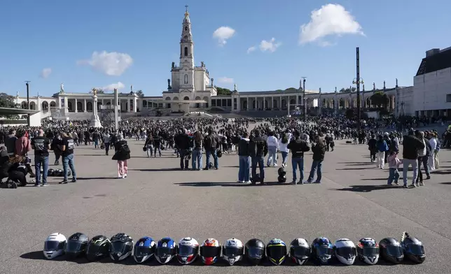 Helmets lie on the ground at the Roman Catholic holy shrine of Fatima, as motorcyclists arrive to have their helmets blessed during the 10th Pilgrimage of the Blessing of Helmets that draws tens of thousands, in Fatima, Portugal, Sunday, Sept. 21, 2025. (AP Photo/Ana Brigida)
