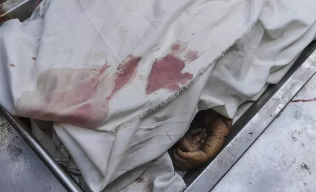 The bodies of members of the Al-Basus family, killed in an Israeli military strike, are covered during their funeral outside Shifa Hospital in Gaza City on Thursday, Sept. 4, 2025. (AP Photo/Jehad Alshrafi)