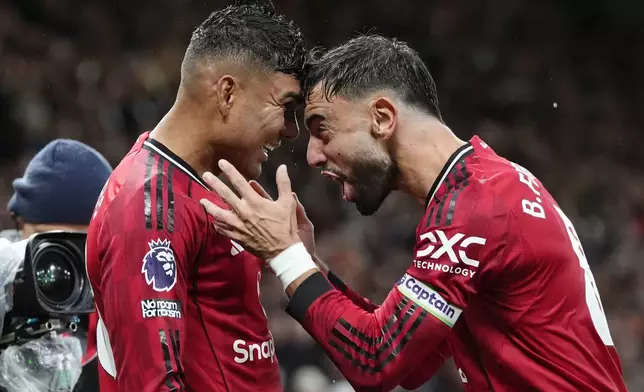 Manchester United's Casemiro, left, celebrates with Bruno Fernandes after scoring their second goal during the English Premier League soccer match between Manchester United and Chelsea at the Old Trafford stadium in Manchester, England, Saturday, Sept. 20, 2025. (Nick Potts/PA via AP)