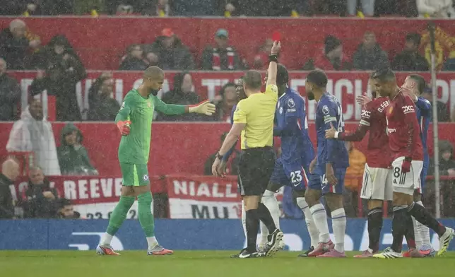 Chelsea's goalkeeper Robert Sanchez, left, reacts after receiving a red card by a referee during the English Premier League soccer match between Manchester United and Chelsea at the Old Trafford stadium in Manchester, England, Saturday, Sept. 20, 2025. (AP Photo/Dave Thompson)