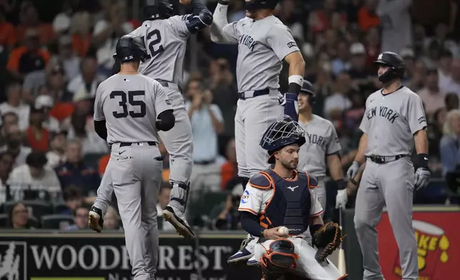 New York Yankees' Trent Grisham (12) celebrates with designated hitter Aaron Judge, top center, after hitting a grand slam during the fifth inning of a baseball game against the Houston Astros in Houston, Tuesday, Sept. 2, 2025. Paul Goldschmidt, Cody Bellinger, and Aaron Judge also scored. (AP Photo/Ashley Landis)
