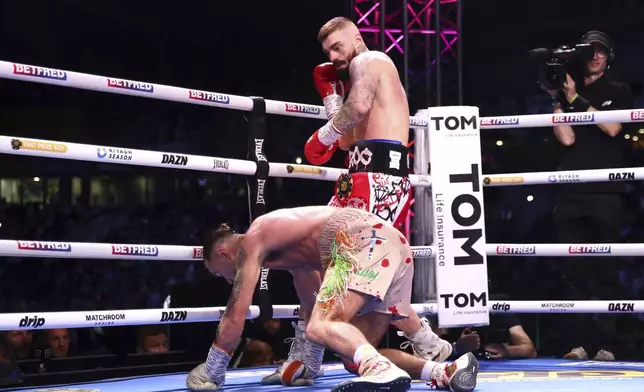 Lewis Crocker, top, knocks down Paddy Donovan during an IBF world welterweight bout at the SSE Arena, Saturday, Sept. 13, 2025, in Belfast, Northern Ireland. (Peter Morrison/PA via AP)