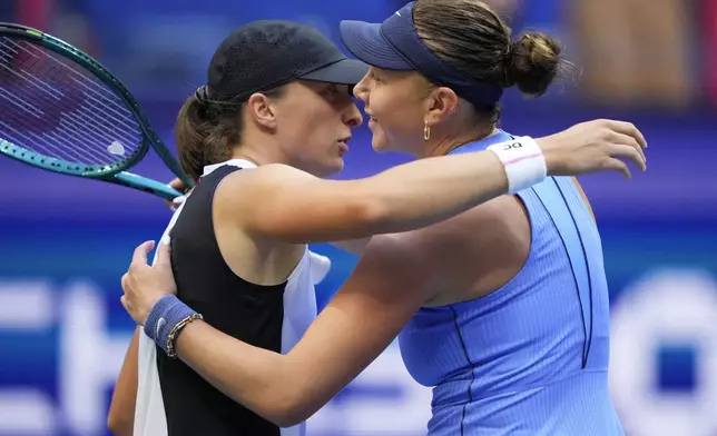 Iga Swiatek, of Poland, hugs Amanda Anisimova, of the United States, after Anisimova defeated Swiatek during the quarterfinal round of the U.S. Open tennis championships, Wednesday, Sept. 3, 2025, in New York. (AP Photo/Yuki Iwamura)