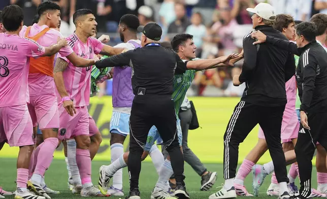 Inter Miami forward Luis Suárez, third from left, is separated from Seattle Sounders players and staff as Sounders midfielder Kalani Kossa-Rienzi, center right facing, holds a staff member back during a fight after the Sounders won the Leagues Cup final soccer match Sunday, Aug. 31, 2025, in Seattle. (AP Photo/Lindsey Wasson)