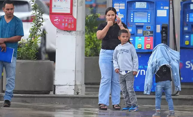 Edwin Cardona, left, who had an appointment at the U.S. Immigration and Customs Enforcement office, stands with his wife Arianny Sierra and their sons, after a shooting at the facility, in Dallas on Wednesday, Sept. 24, 2025. (AP Photo/Julio Cortez)