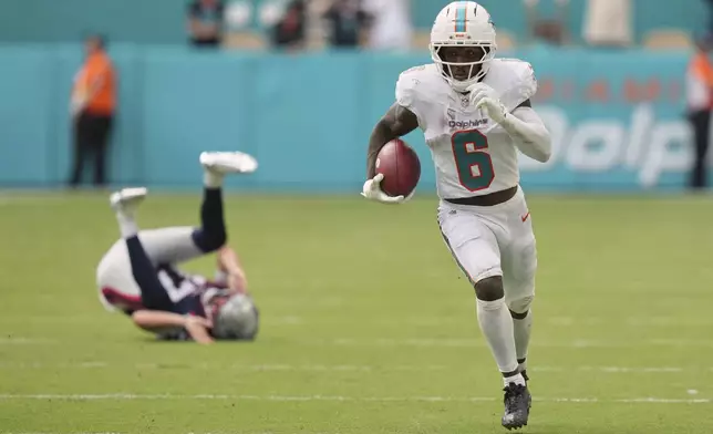 Miami Dolphins' Malik Washington gets past New England Patriots punter Bryce Baringer for a touchdown on a punt return during the second half of an NFL football game Sunday, Sept. 14, 2025, in Miami Gardens, Fla. (AP Photo/Lynne Sladky)
