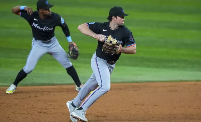 Miami Marlins second baseman Graham Pauley, right, fields a groundout by Texas Rangers' Josh Smith as teammate shortstop Otto Lopez mimics the motion during the sixth inning of a baseball game Friday, Sept. 19, 2025, in Arlington, Texas. (AP Photo/Julio Cortez)