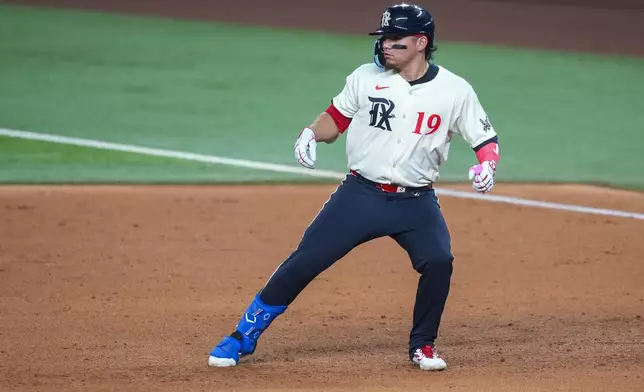 Texas Rangers' Alejandro Osuna turns the base while running out a single against the Miami Marlins during the sixth inning of a baseball game Friday, Sept. 19, 2025, in Arlington, Texas. (AP Photo/Julio Cortez)