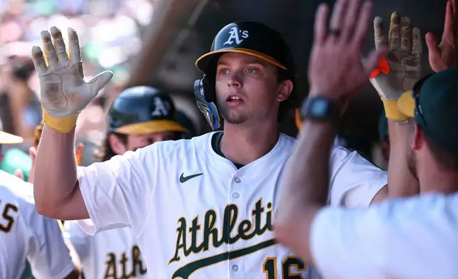 Athletics' Nick Kurtz celebrates in the dugout after hitting a two-run home run during the fifth inning of a baseball game against the Cincinnati Reds, Sunday, Sept. 14, 2025, in West Sacramento, Calif. (AP Photo/Sara Nevis)