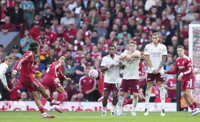 Liverpool's Dominik Szoboszlai, left, shoots to score his sides first goal during the English Premier League soccer match between FC Liverpool and FC Arsenal in Liverpool, England, Sunday, Aug. 31, 2025. (AP Photo/Jon Super)