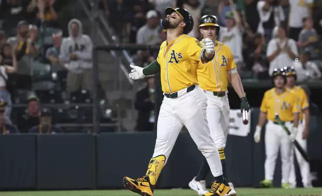 Athletics' Carlos Cortes, left, celebrates after hitting a solo home run during the third inning of a baseball game against the Cincinnati Reds, Friday, Sept. 12, 2025, in West Sacramento, Calif. (AP Photo/Sara Nevis)
