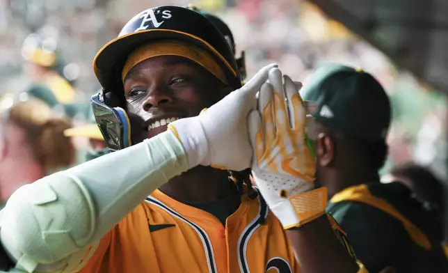 Athletics' Lawrence Butler celebrates in the dugout after hitting a solo home run during the first inning of a baseball game against the Cincinnati Reds Friday, Sept. 12, 2025, in West Sacramento, Calif. (AP Photo/Sara Nevis)