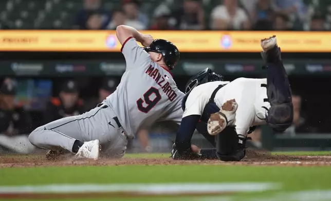 Detroit Tigers catcher Dillon Dingler (13) tags Cleveland Guardians first base Kyle Manzardo (9) out at home plate during the 10th inning of a baseball game Tuesday, Sept. 16, 2025, in Detroit. (AP Photo/Paul Sancya)