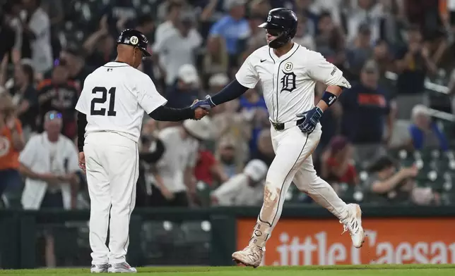 Detroit Tigers' Spencer Torkelson celebrates his two-run home run with third base coach Joey Cora (56) during the 10th inning of a baseball game against the Cleveland Guardians Tuesday, Sept. 16, 2025, in Detroit. (AP Photo/Paul Sancya)