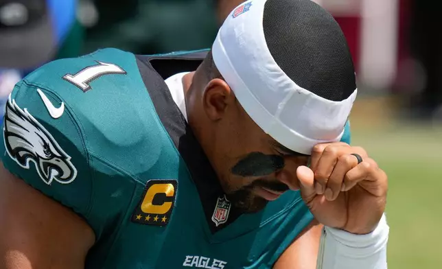 Philadelphia Eagles quarterback Jalen Hurts (1) kneels before an NFL football game against the Tampa Bay Buccaneers, Sunday, Sept. 28, 2025, in Tampa, Fla. (AP Photo/Chris O'Meara)