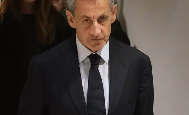 Former French President Nicolas Sarkozy leaves after a Paris court sentenced him to 5 years after finding him guilty of criminal conspiracy in an alleged scheme to finance his 2007 campaign with funds from Libya, Thursday, Sept. 25, 2025 in Paris. (AP Photo/Christophe Ena)
