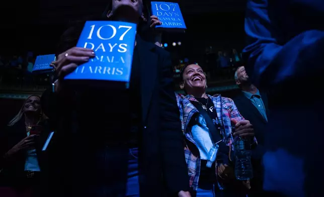 People display their copies of former Vice President Kamala Harris' new book "107 Days," about her presidential campaign on the first stop of the book's tour at Town Hall in New York, Wednesday, Sept. 24, 2025. (AP Photo/Angelina Katsanis)
