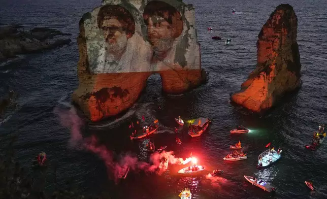 Portraits of two former Hezbollah leaders Hassan Nasrallah, right and Hashem Safieddine, left, are projected onto the landmark Raouche sea rock during an event commemorating their deaths in Israeli airstrikes nearly a year ago, in Beirut, Lebanon, Thursday, Sept. 25, 2025. (AP Photo/Hussein Malla)