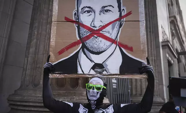 Asher Rogers holds an image of Jimmy Kimmel outside El Capitan Entertainment Centre, where the late-night show "Jimmy Kimmel Live!" is staged on Thursday, Sept. 18, 2025, in Los Angeles. (AP Photo/Jae C. Hong)