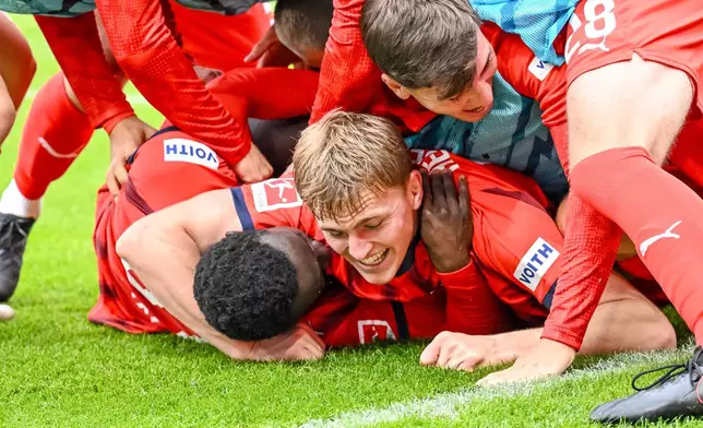 Heidenheim's Sirlord Conteh, bottom, celebrates with teammates after scoring during the German Bundesliga soccer match between FC Heidenheim and FC Augsburg at the Voith-Arena in Heidenheim, Germany, Saturday, Sept. 27, 2025. (Harry Langer/dpa via AP)