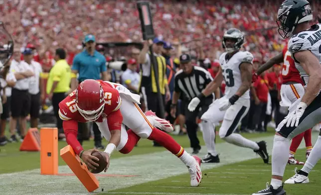 Kansas City Chiefs quarterback Patrick Mahomes (15) scores during the first half of an NFL football game against the Philadelphia Eagles Sunday, Sept. 14, 2025, in Kansas City, Mo. (AP Photo/Ed Zurga)