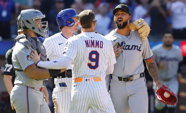 New York Mets' Brandon Nimmo (9) talks to Miami Marlins pitcher Sandy Alcantara after hitting Mets' Mark Vientos during the seventh inning of a baseball game, Sunday, Aug. 31, 2025, in New York. (AP Photo/Noah K. Murray)