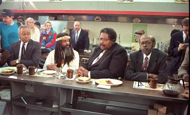 FILE - The four black men who were once denied service at the Woolworth store in Greensboro, N.C. take their places at the same lunch counter to recreate their sit-in on Feb. 2, 1990. The men are, from left, Joseph McNeil, Jibreal Khazan (formerly Ezell Blair, Jr.), Franklin McCain, and David Richmond. (AP Photo/Chuck Burton, File)